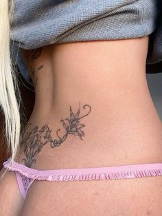 a woman's stomach with tattoos on it