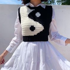 a woman wearing a white dress with black and white crochet