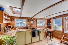 a kitchen with wood paneling and lots of counter space next to a large window