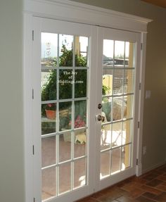 two white french doors open to a patio