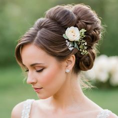 a woman with a flower in her hair wearing a wedding dress and holding a bouquet