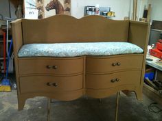 a wooden dresser with drawers and a blue blanket on top