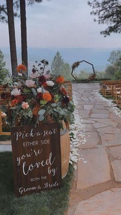 a wooden barrel with flowers and greenery on it is sitting in the grass next to an aisle