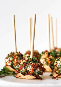 several appetizers with toothpicks in them on a white plate