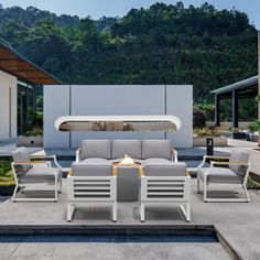 an outdoor fire pit and seating area with mountains in the background