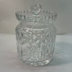 a clear glass jar with a lid on a white surface