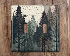 a light switch cover with pine trees painted on it and polka dots in the sky