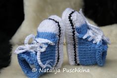 a pair of blue and white crocheted baby shoes