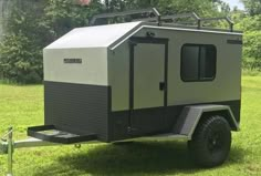 an off - road camper is parked in the grass