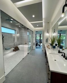 a large bathroom with two sinks and a walk in shower next to the bathtub