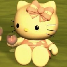 a hello kitty doll sitting on the ground next to a pink flower and an egg