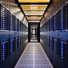 the inside of a server room with rows of blue and white servers on either side