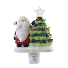 a glass christmas tree and santa clause on a light switch cover with a white star