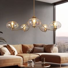 a living room filled with furniture and a large window covered in glass globes hanging from the ceiling