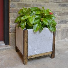 a planter that is sitting outside on the ground next to a brick wall with text overlay reading easy diy wood and concrete planter