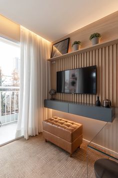 a living room with a flat screen tv mounted to the wall next to a sliding glass door