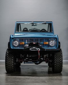 the front end of a blue truck parked in a garage