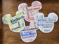 mickey mouse shaped stickers with the names of all disney characters in different languages on a wooden surface