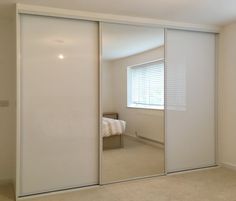 an empty bedroom with sliding glass doors leading to a bed and closet space in the corner