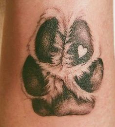 a close up of a person's foot with a paw tattoo on their leg