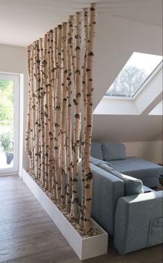 a living room with couches and curtains in the window sill next to an open skylight