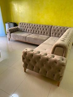 a living room with two couches and a television on top of the table in front of a yellow wall