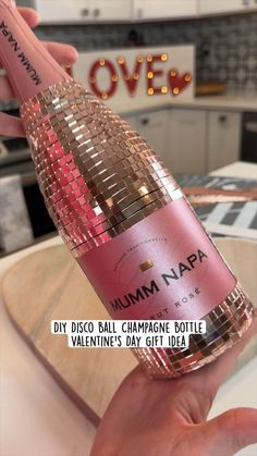 a person holding a bottle of champagne with the caption saying diy disco ball champagne bottle valentine's day gift idea