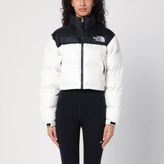 White nylon cropped down jacket from The North Face, featuring a high collar, a zip front fastening, an embroidered logo on the chest and back, two front zipped pockets and a drawstring at the bottom. White Streetwear Outerwear With Padded Collar, Sporty The North Face Puffer Jacket, Sporty Cropped Outerwear With Zipper Closure, Sporty White Outerwear With Padded Collar, White Hooded Puffer Jacket Functional, White Hooded Sporty Puffer Jacket, White Nylon Puffer Jacket For Fall, Casual White Nylon Puffer Jacket, White Sporty Puffer Jacket For Streetwear