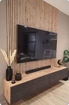 a flat screen tv mounted to the side of a wooden wall in a living room