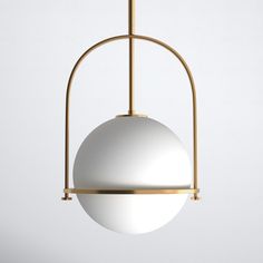 a white ball hanging from a brass frame with a round light fixture in the middle