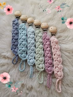 four crochet keychains with wooden buttons on them sitting on a white furnishing