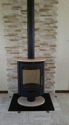 a wood burning stove in front of a brick wall with a black and white floor