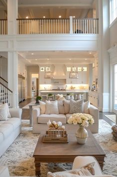 a living room filled with furniture and a staircase leading to the second floor above it