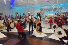 a group of people that are standing in the middle of a room with some drums