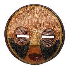 a wooden mask with two large eyes on it's face and an intricate design