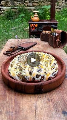 a cake sitting on top of a wooden table covered in cheese and other food items