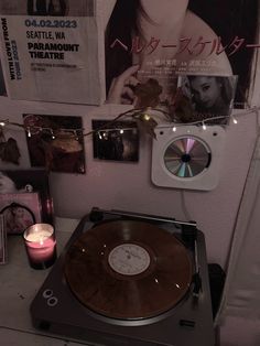 a record player sitting on top of a table next to a wall with pictures and candles