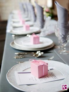 the table is set with pink napkins and place settings for an elegant dinner party