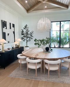 a dining room table surrounded by white chairs