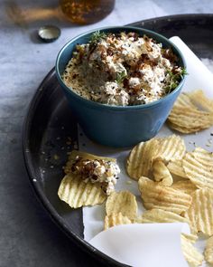 a blue bowl filled with food sitting on top of a plate next to crackers