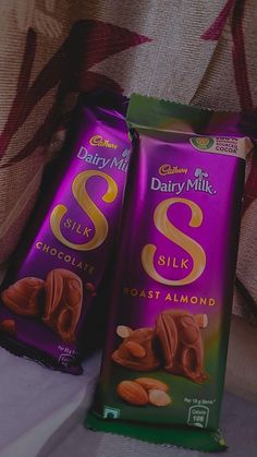 two bags of dairy milk sit next to each other on a couch, one is filled with almonds