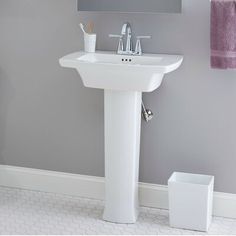 a white pedestal sink sitting under a mirror