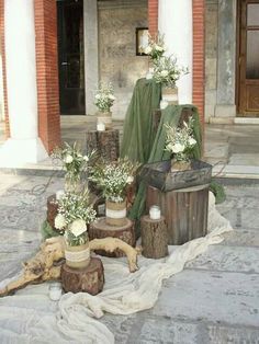 there are many vases with flowers in them on the ground next to some logs