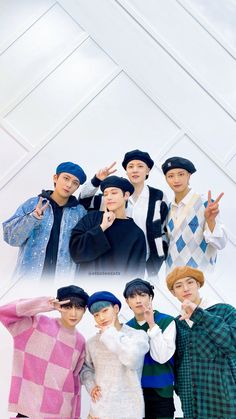 the group is posing together in front of a white wall and wearing blue hats, sweaters and checkered shirts