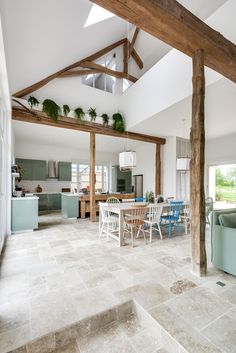 a living room filled with furniture next to a kitchen and dining room table covered in blue chairs