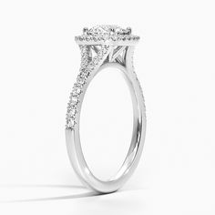 a white gold engagement ring with two rows of diamonds on the band and an oval shaped center