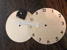 two wooden clocks sitting on top of a table next to each other, one has the time