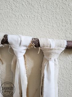 a white curtain hanging on the side of a wall next to a brown and white tie