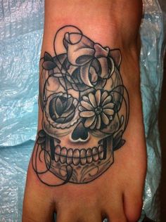 a foot with a skull and flowers on it