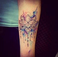 a woman's arm with a watercolor tattoo design on the left side of her leg